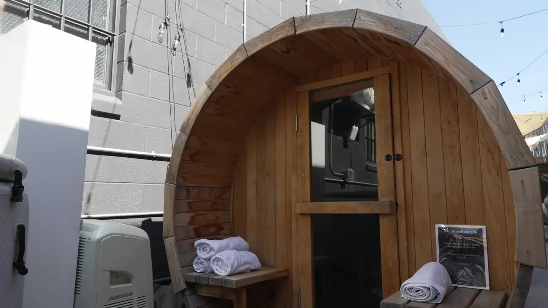 The cedar barrel sauna with towels folded at the door